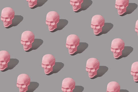 Pastel pink Skull pattern with sharp shadows on gray background. Authentic Halloween creative fun and costume party concept.の写真素材