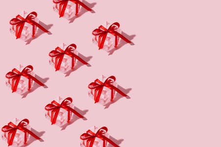 Christmas pattern made with real ice cubes gifts on pink pastel background. Minimal New Year party...