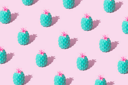 Pattern made of mint toy pineapple or ananas on bright pink pastel background. Fun composition of...