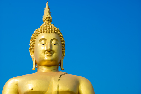 The big golden buddha statue located in Thailand with blue sky background on sunny dayの写真素材