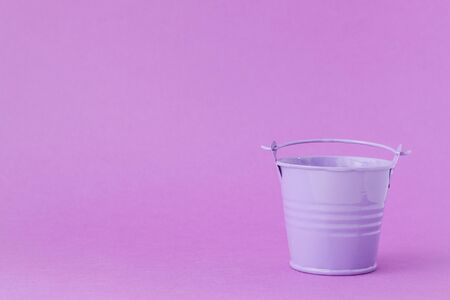 Toy iron bucket light purple on a dark purple background.の写真素材