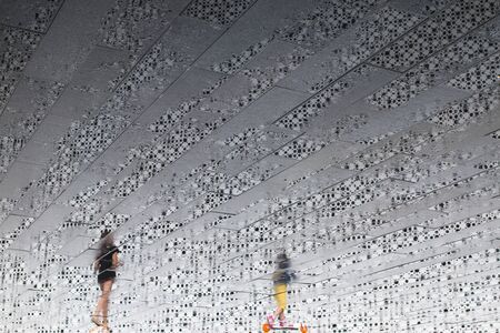 Two running girls on the background of a textured white wall. Reflection on a wet tile after rain.