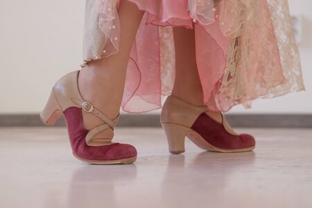Pink and beige shoes for flamenco dance on women's legs. Close-up.の写真素材