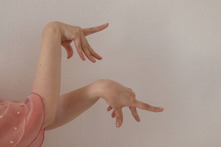 Hands of a woman dancing flamenco dance on a white background. Close-up.