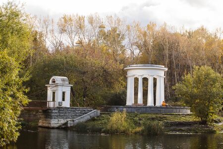 Old park in the fall. View of the island with a white rotunda and an arch.の写真素材