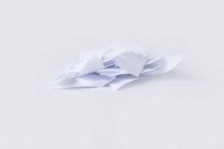 A pile of torn into small pieces of white paper on a white background. isolated.の写真素材
