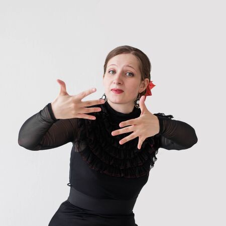 Half-length portrait of beautiful young woman dancing flamenco in a black dress.の写真素材