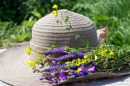 Summer composition. A bouquet of wildflowers and a female sun hat.の写真素材