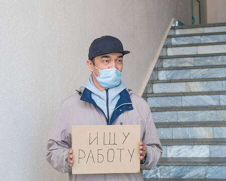 Need a job, asian unemployed adult male in a mask with poster.