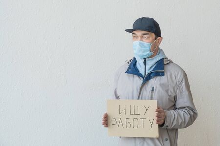 Need a job, asian unemployed adult male in a mask with poster.