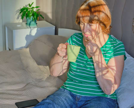 Senior woman using a laptop in her bedroom at home. Happy retired person shopping online on the bed. Lifestyle Copy spaceの写真素材