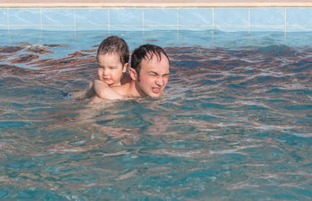 Happy father and son spend time together swimming in the thermal pool.の写真素材