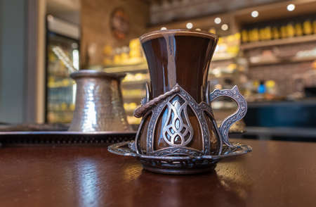 Fresh strong Turkish coffee in a beautiful glass in Oriental style is on the table in the cafeの写真素材