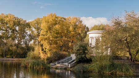 Old park in the fall. View of the lake and the white rotunda. Banner Kharitonovsky Park, Yekaterinburg, Russiaの写真素材