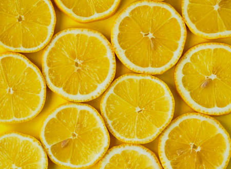 Sliced lemons in round slices on yellow background. Top viewの写真素材