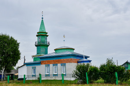 Tyumen, Russia - August 16, 2020: Local mosque from white bricks with a wooden green minaret in the Siberian village Sabanaki on a nasty dayのeditorial素材