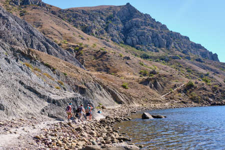Tourists walks along the path of the rocky coast of Cape Meganom on the Black Sea, Crimea peninsula.の写真素材