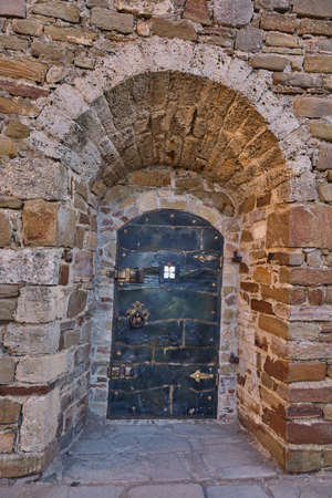 An iron door in a wall of a medieval Genoise fortress in Sudak, Crimean peninsula.の写真素材