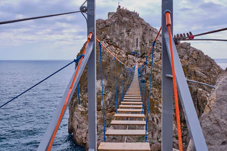 The suspension bridge to rock Diva. The black sea coast near Yalta, town Simeiz, Crimea. Coastal seascape landscape.の写真素材