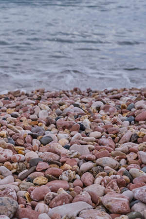 Beautiful seascape. A pebble beach without people with an incoming wave. Transparent clean water.の写真素材