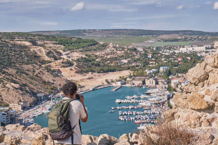 Top view of the Balaklava Bay, city Sevastopol, Crimean Peninsula, Russia. A male tourist with a...