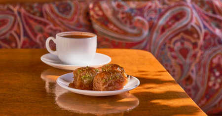 Eastern sweetness, Turkish baklava, fresh black coffee in a white cup on a old wooden table with shadow.の写真素材
