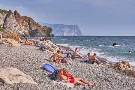 People rest, swim and sunbathe on the pebble Yashmovy beach, Cape Fiolent in the Balaklava region. Black Sea, Crimea peninsulaのeditorial素材