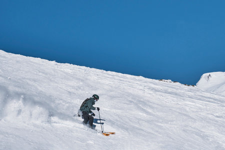 Terskol, Russia - January 24, 2021: A guy on alpine skiing descends the snowy slope of Cheget mountain.のeditorial素材