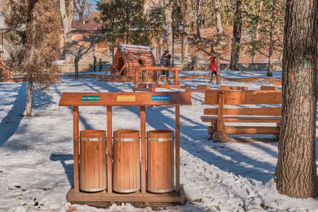 Wooden stylized garbage bins for sorting waste in a city park. Russian text - paper, plastic, glass.の写真素材