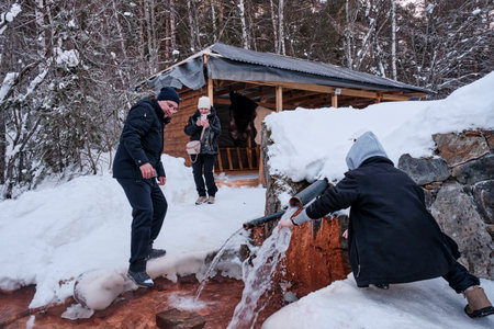 Kislovodsk, Russia - January 24, 2021: In winter, people filling bottles and glasses with healing water from a mineral spring. Narzan Valley, Caucasian Mineral Waters.のeditorial素材