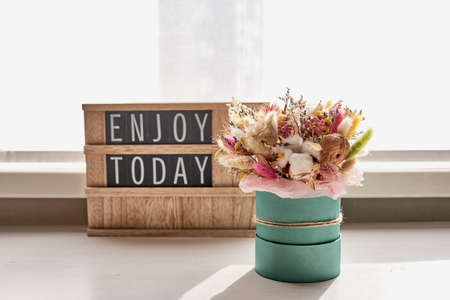 A beautiful bouquet of dried flowers on the table near the windowの写真素材