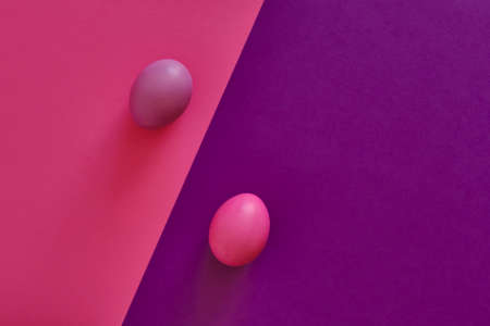 Abstract combined violet-pink background with diagonal. Painted violet egg on a pink background, painted pink egg on a violet background.の写真素材