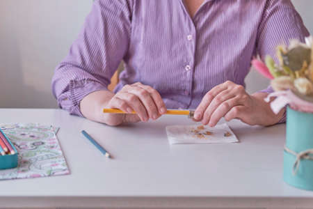 Senior womans hands holding a colored pencil and painted pages from adult coloring pages.の写真素材