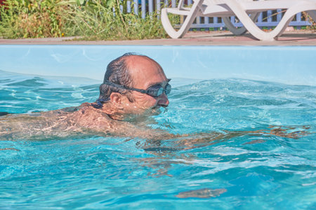 A man swims in a pool in the courtyardの写真素材