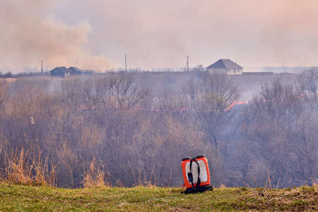 Firefighting backpack on the background of Grassroots Wildland Fire.の写真素材