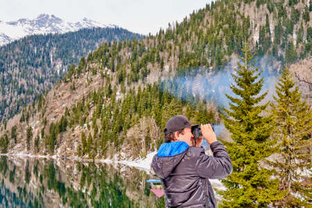 A man in takes a picture of a beautiful winter landscape of the Caucasus mountains and Lake Ritsaの写真素材