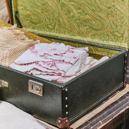 An antique white handmade tablecloth with cutwork embroidery in an old suitcase.の写真素材