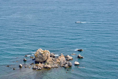 A pile of large rocky stones lying in the water. View from above.の写真素材