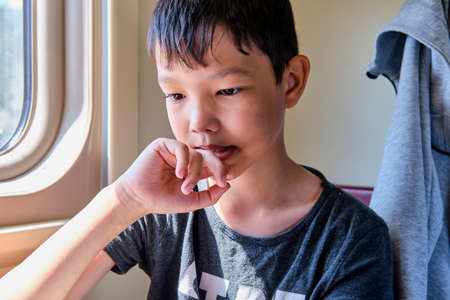Close-up portrait of young asian thinking boyの写真素材