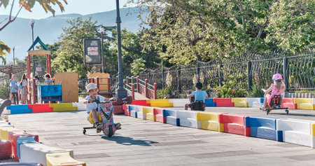 Little boys riding an electric drift kart scooters in park of attractions on a summer sunny day.のeditorial素材
