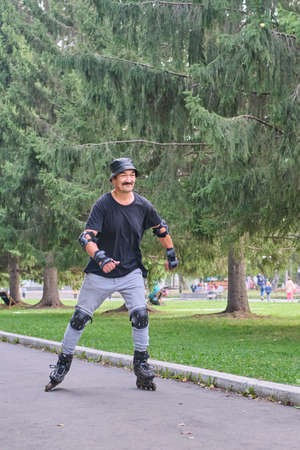 Active senior asian man is roller skating in park.の写真素材