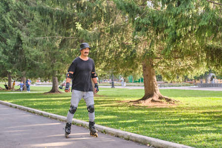 Active senior asian man is roller skating in park.の写真素材