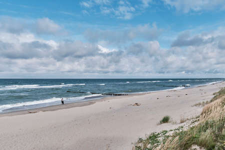 Beautiful seascape with waves, sandy beach and cloudy sky.の写真素材