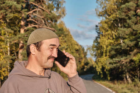 Senior Muslim asian man talking on phone and smilingの写真素材