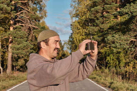 Senior Muslim asian man shooting video for his blog on mobile phoneの写真素材