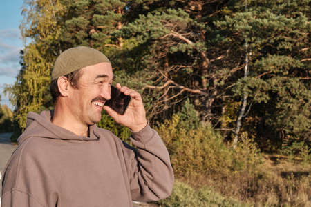 Senior Muslim asian man talking on phone and smilingの写真素材