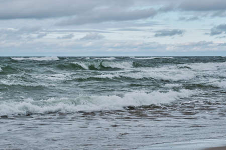 Beautiful seascape with big waves, dramatic cloudy skyの写真素材