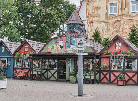 Signpost with arrows and wooden colorful small houses with Baltic souvenirs in tourist area.のeditorial素材