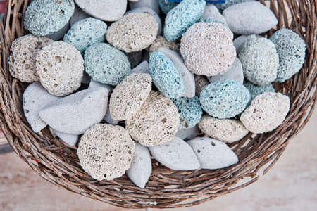 Colored pumice stones for feet in basket as souvenirs for tourists. Volcanic rock with porous structure.の写真素材