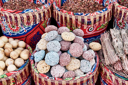 Colored pumice stones for feet in basket as souvenirs for tourists. Volcanic rock with porous structure.の写真素材